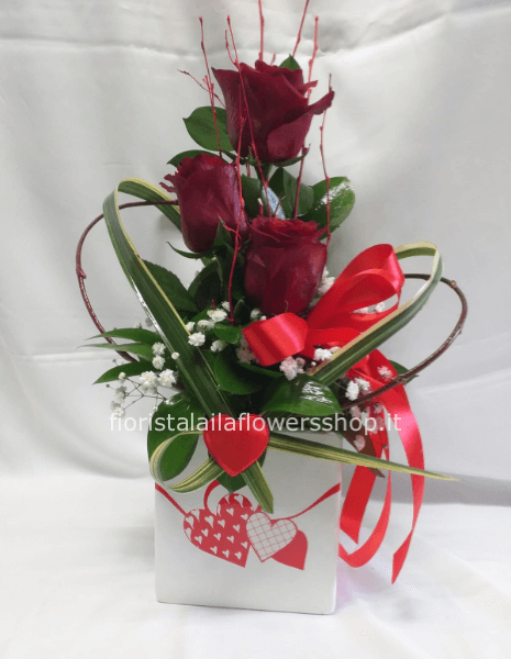 tre rose rosse in contenitore di ceramica 